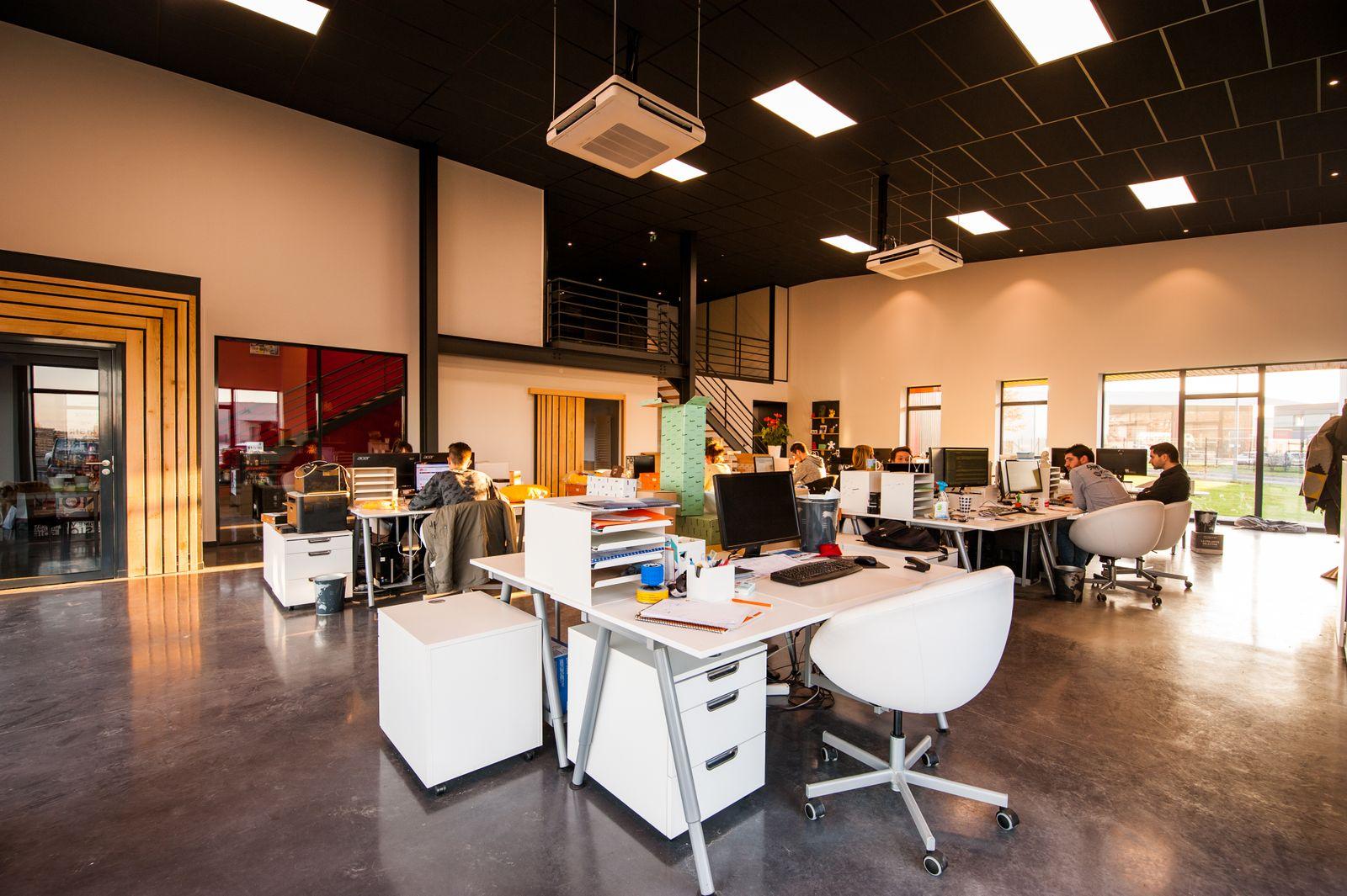 An open office with desks, chairs, and workstations.